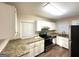 Well-lit kitchen featuring stainless steel appliances, granite countertops, and white cabinetry at 1901 Clarke Ln, Decatur, GA 30035