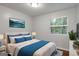 Light-filled bedroom features a bed, window, art, and side tables at 2894 Cushing Ct, Jonesboro, GA 30236
