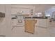 Well-lit kitchen with white appliances, ample counter space, and an island with rolling cart at 150 Butterton Ct, Fayetteville, GA 30214
