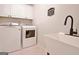Laundry room with a washer, dryer, sink, and storage cabinets at 150 Butterton Ct, Fayetteville, GA 30214