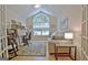 Bright home office featuring ample natural light, hardwood floors, and functional furnishings at 150 Butterton Ct, Fayetteville, GA 30214