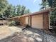 Exterior view of the home with a garage and a wooden deck, surrounded by lush greenery and trees at 224 Potts Se Rd, Conyers, GA 30094