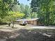Beautiful exterior of home with natural wood siding, a deck, and a large yard with mature trees at 224 Potts Se Rd, Conyers, GA 30094