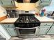 Kitchen area featuring a stainless steel gas range and matching cabinets at 224 Potts Se Rd, Conyers, GA 30094