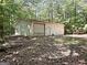 A shed with a roll-up door and side entrance nestled among the trees at 224 Potts Se Rd, Conyers, GA 30094