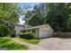 Exterior of home showing the garage, driveway and landscaped lawn with mature trees at 3308 Quail Sw Run, Marietta, GA 30008