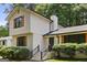 Two-story white house features black trimmed windows and wood-look shutters, with stairs leading to the front door at 3308 Quail Sw Run, Marietta, GA 30008