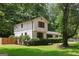 Two-story white home features black trimmed windows and wood-look shutters, surrounded by lush greenery at 3308 Quail Sw Run, Marietta, GA 30008