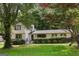 Charming two-story home with a well-manicured lawn, surrounded by lush trees, features black trimmed windows and wood-look shutters at 3308 Quail Sw Run, Marietta, GA 30008