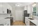 Modern kitchen features white cabinets, stainless appliances, and white subway tile backsplash at 3308 Quail Sw Run, Marietta, GA 30008