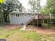 View of the backyard with wooden deck and stairs leading down to the yard at 5405 Lakeside Dr, Union City, GA 30291