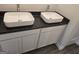 Bathroom with stylish square sinks atop a black granite countertop and modern white cabinets for a clean, sophisticated look at 1672 Fuma Leaf Way Rd, Mcdonough, GA 30253