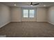 Spacious bedroom with plush carpeting, a ceiling fan, and plenty of natural light, creating a warm and welcoming atmosphere at 1672 Fuma Leaf Way Rd, Mcdonough, GA 30253