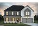 Charming two-story home features a classic design with a welcoming front porch and attached two-car garage at 1672 Fuma Leaf Way Rd, Mcdonough, GA 30253