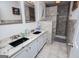 Bathroom with double sink vanity, granite counters, and a tiled walk-in shower at 7358 S Mitchell Ct, Villa Rica, GA 30180