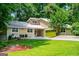 Charming home with a metal roof, a green garage door and a well-manicured front yard at 7358 S Mitchell Ct, Villa Rica, GA 30180
