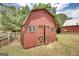 Exterior view of a barn with open wooden doors, showing its rustic red finish and surrounding greenery at 1024 Bethany Rd, Covington, GA 30016