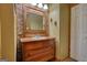 Unique bathroom with brick accent wall, antique vanity and decorative sconces at 1024 Bethany Rd, Covington, GA 30016
