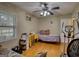 Bedroom with hardwood floors, ceiling fan, window with blinds and exercise equipment at 1024 Bethany Rd, Covington, GA 30016