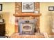 Close-up of a brick fireplace with wood mantel, metal Heritage stove, and displayed decor at 1024 Bethany Rd, Covington, GA 30016