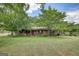 Charming brick home with a lovely front porch and mature trees in a large manicured lawn at 1024 Bethany Rd, Covington, GA 30016