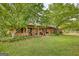 Lovely brick home showcases a welcoming front porch with ample seating options, surrounded by lush greenery at 1024 Bethany Rd, Covington, GA 30016