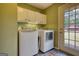 Laundry room with washer, dryer, cabinet storage, and outdoor access at 1024 Bethany Rd, Covington, GA 30016