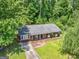 An aerial view shows a charming brick home surrounded by lush greenery and a well-manicured lawn at 1356 Lori Ct, Conley, GA 30288