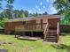 Exterior of a brick home with a wooden deck and stairs leading to the grassy backyard at 1356 Lori Ct, Conley, GA 30288