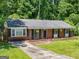 Charming brick home with well-maintained front yard, landscaping, and inviting front porch at 1356 Lori Ct, Conley, GA 30288
