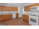 Functional kitchen with white appliances, wood cabinets, and neutral counter, offering a practical layout at 1356 Lori Ct, Conley, GA 30288