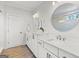 Bright bathroom features a double vanity with marble countertops, modern fixtures and round mirrors at 229 Widener Way, Peachtree City, GA 30269
