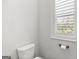 Neutral powder room features a window with a light-filtering shade and a modern toilet at 229 Widener Way, Peachtree City, GA 30269