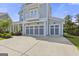 Attached three-car garage featuring decorative doors with a balcony overhead at 229 Widener Way, Peachtree City, GA 30269