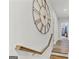 Inviting hallway with wood floors, staircase, and a striking decorative clock accenting the neutral wall at 229 Widener Way, Peachtree City, GA 30269