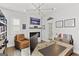 View of the home office with a modern light fixture, brick fireplace, and hardwood flooring at 229 Widener Way, Peachtree City, GA 30269