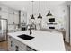 Modern kitchen featuring an island with white countertop, black faucet, pendant lighting, and open view to the living room at 229 Widener Way, Peachtree City, GA 30269