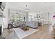 Open-concept living room featuring hardwood floors, a comfortable sectional sofa, and backyard views at 229 Widener Way, Peachtree City, GA 30269