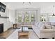Bright living room with a large sectional sofa, fireplace, and floor to ceiling windows with backyard views at 229 Widener Way, Peachtree City, GA 30269