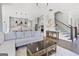 Open concept living area showcasing a gray sofa, center island and adjacent staircase at 229 Widener Way, Peachtree City, GA 30269