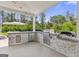 Outdoor kitchen with stone accents, stainless steel appliances, and covered grilling area at 229 Widener Way, Peachtree City, GA 30269