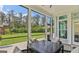 Relaxing screened patio with table and chairs overlooking a lush green backyard featuring a play set at 229 Widener Way, Peachtree City, GA 30269