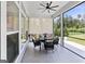 Inviting screened porch with a dining table set, ceiling fan, and views of the landscaped backyard at 229 Widener Way, Peachtree City, GA 30269