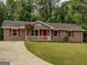 Charming single-story home with a well-manicured front yard and red door at 170 Hidden Pines Drive, Covington, GA 30016