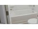 Clean white bathroom featuring a bathtub with a shower and a white toilet at 524 Harmony Way, Locust Grove, GA 30248