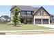 Charming two-story home with a well-manicured lawn and a two-car garage. A lovely tree adds to the curb appeal at 524 Harmony Way, Locust Grove, GA 30248