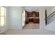 Open-concept living space with staircase and a view into the kitchen featuring dark cabinets at 524 Harmony Way, Locust Grove, GA 30248