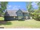Blue two-story home's backyard featuring well-maintained lawn, mature trees, and a serene setting at 1478 Interlaken Pass, Jonesboro, GA 30238