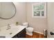 A clean half bathroom with a sink, toilet, and a window for natural light at 1478 Interlaken Pass, Jonesboro, GA 30238