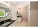 Bright bathroom with a double vanity, black countertops, and a large round mirror at 1478 Interlaken Pass, Jonesboro, GA 30238